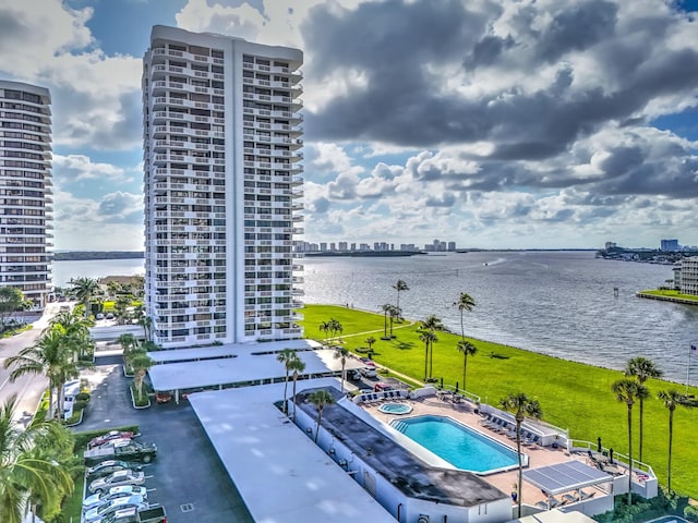 view of swimming pool featuring a water view, a city view, and a patio