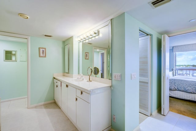 bathroom featuring baseboards, visible vents, vanity, and ensuite bath