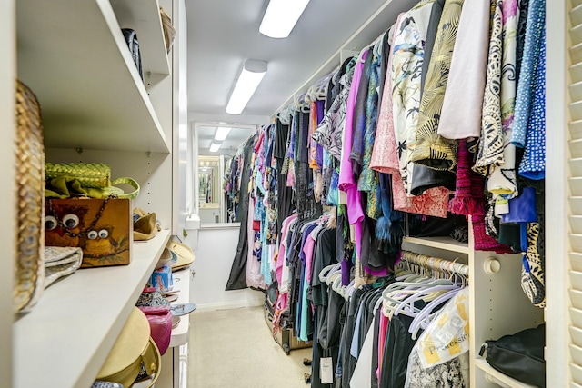 walk in closet featuring light carpet