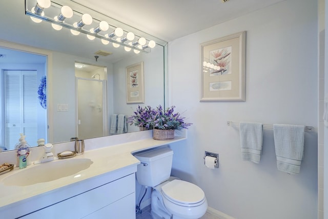 bathroom with a stall shower, baseboards, toilet, vanity, and a closet