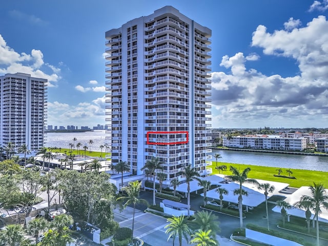 view of building exterior featuring a water view and a city view