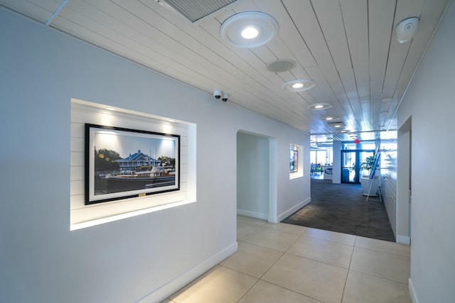 hallway featuring light tile patterned floors, visible vents, light colored carpet, wood ceiling, and recessed lighting