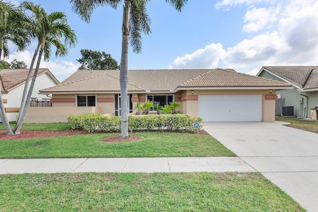 single story home featuring cooling unit, a garage, and a front lawn