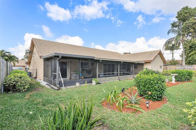 rear view of property featuring a yard and a sunroom