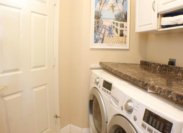 washroom with cabinets and washing machine and dryer