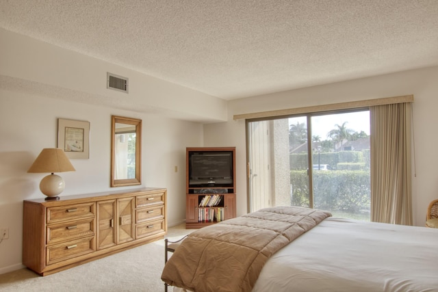 bedroom featuring multiple windows, access to outside, light carpet, and a textured ceiling