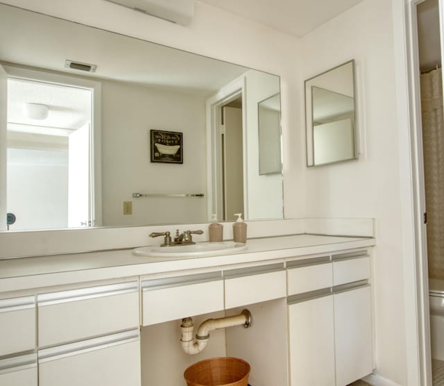 bathroom featuring vanity and toilet