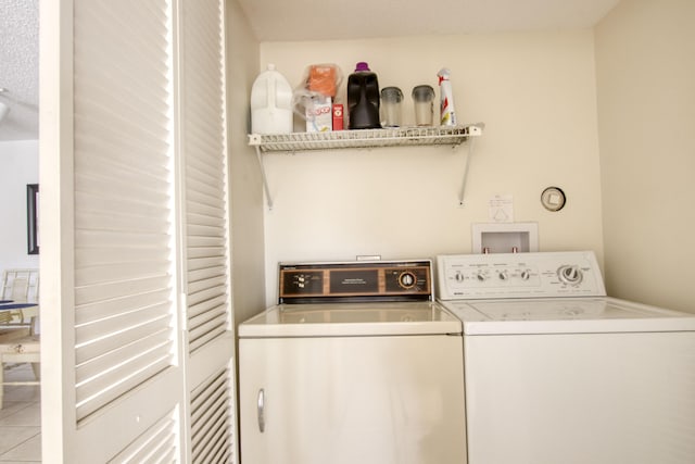 clothes washing area with tile patterned flooring and washing machine and clothes dryer