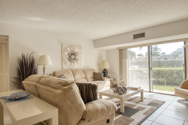 living room with a textured ceiling and light tile patterned flooring