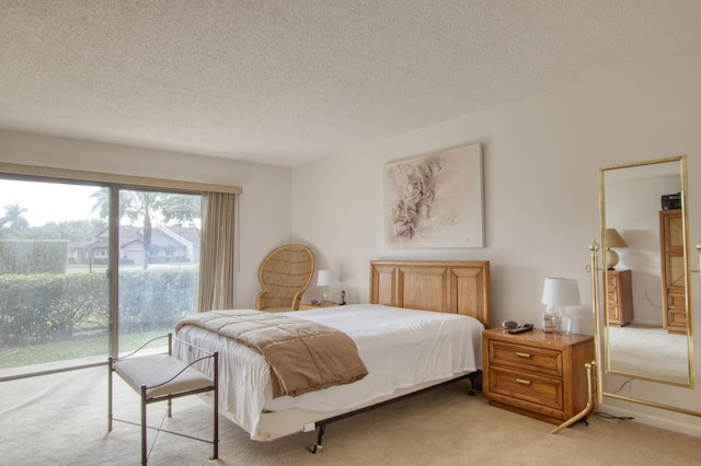 carpeted bedroom featuring access to outside and a textured ceiling