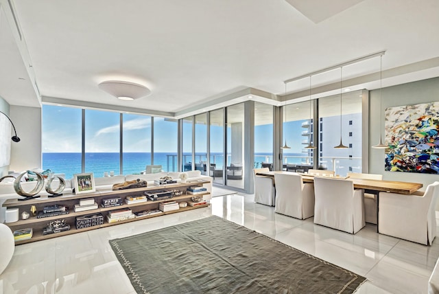 tiled living room with a water view, plenty of natural light, and a wall of windows