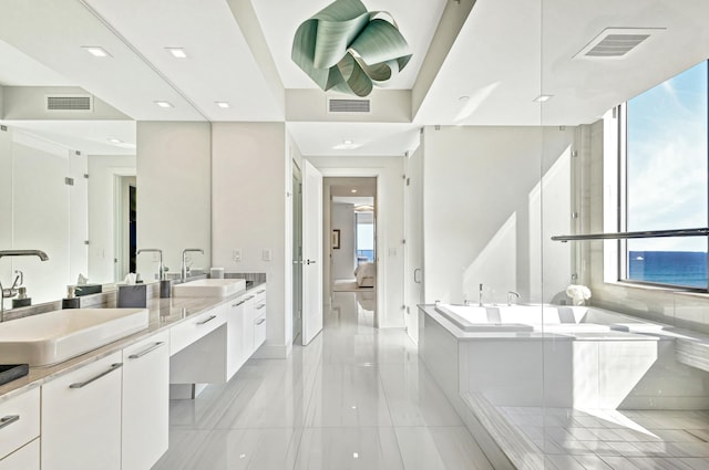 bathroom featuring a water view, vanity, and a washtub