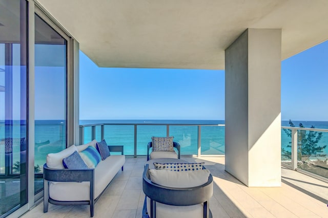 balcony with an outdoor living space and a water view