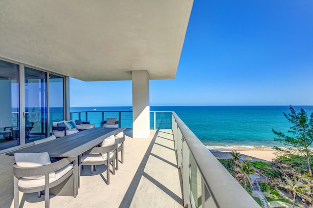 balcony featuring a beach view and a water view