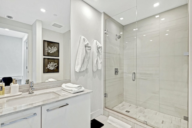 bathroom featuring vanity and a shower with door