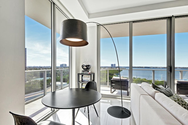 dining space featuring a wall of windows, light tile patterned flooring, and a water view