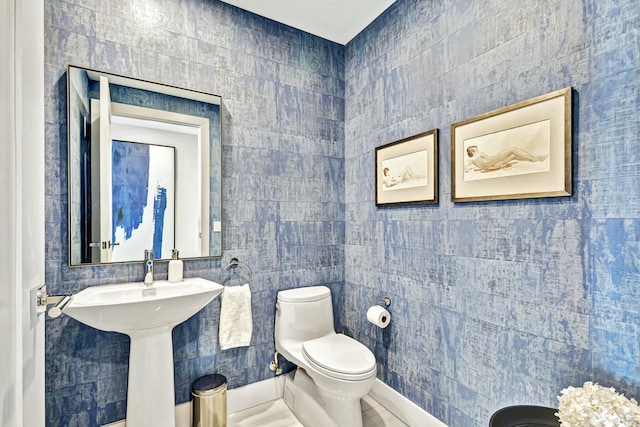 bathroom with tile walls and toilet