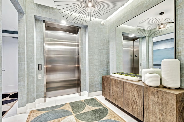 bathroom with tile patterned flooring, vanity, elevator, and tile walls