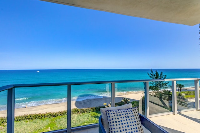 balcony with a water view and a view of the beach