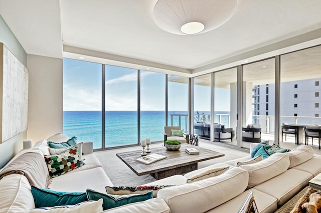 carpeted living room with floor to ceiling windows and a water view