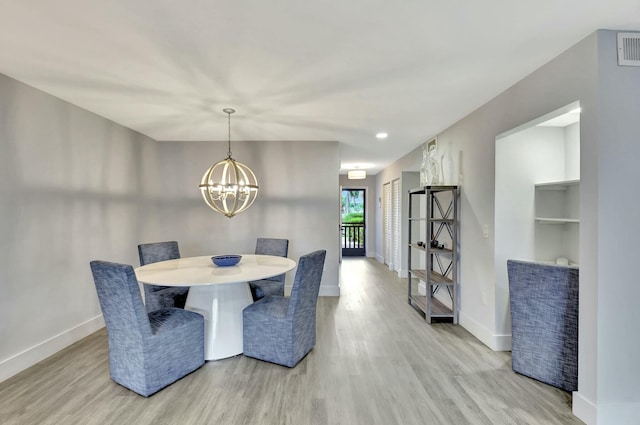 dining room with a notable chandelier and light hardwood / wood-style floors