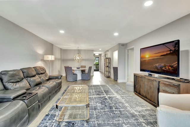 living room with a chandelier and light hardwood / wood-style floors