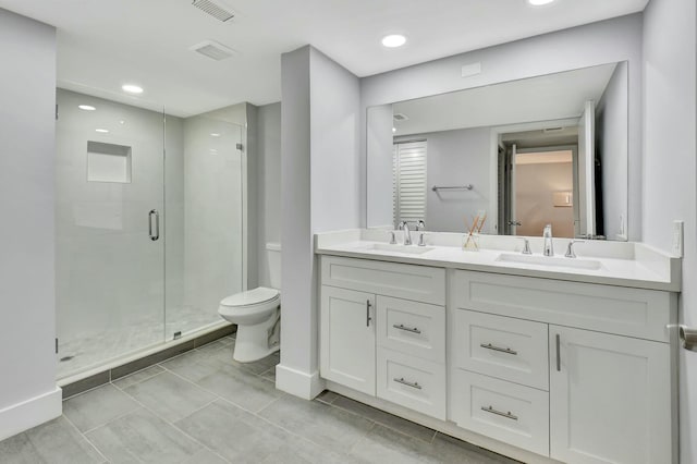 bathroom with vanity, toilet, and a shower with door