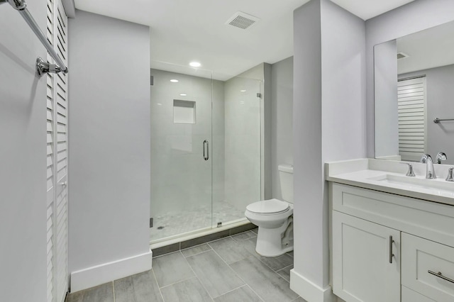 bathroom with walk in shower, vanity, and toilet