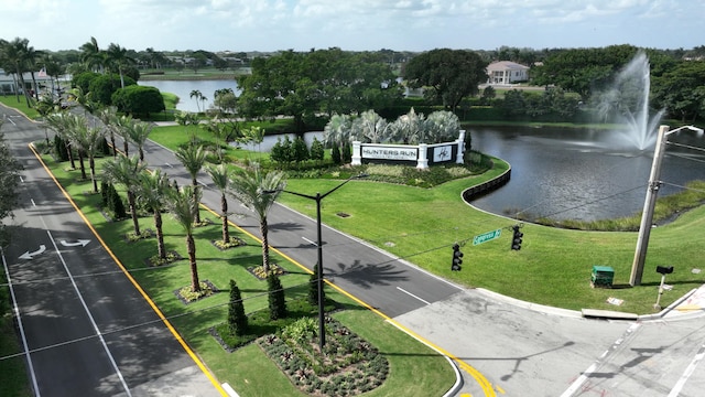 surrounding community featuring a water view and a lawn