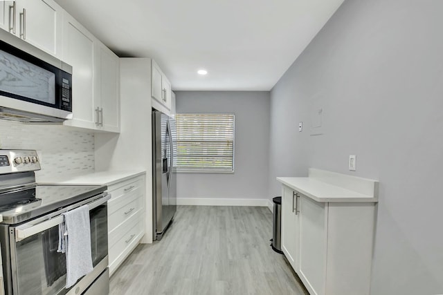 kitchen with tasteful backsplash, white cabinetry, appliances with stainless steel finishes, and light wood-type flooring