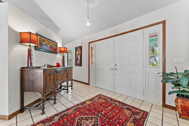 entryway with a textured ceiling and light tile patterned floors