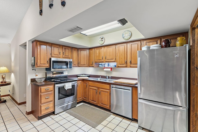 kitchen with stainless steel appliances, sink, and light tile patterned floors