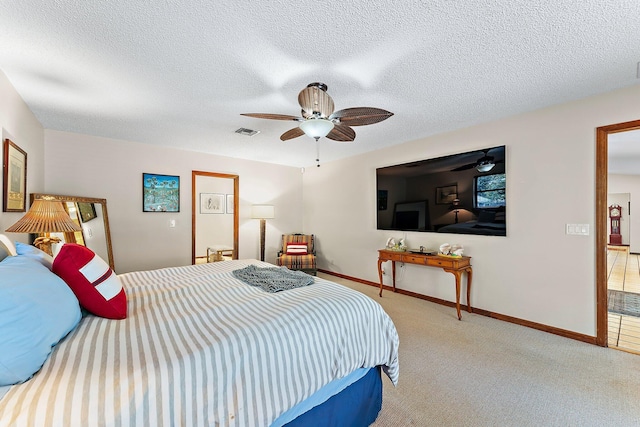 carpeted bedroom with ceiling fan and a textured ceiling