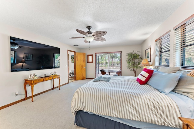 bedroom with ceiling fan, light colored carpet, and a textured ceiling