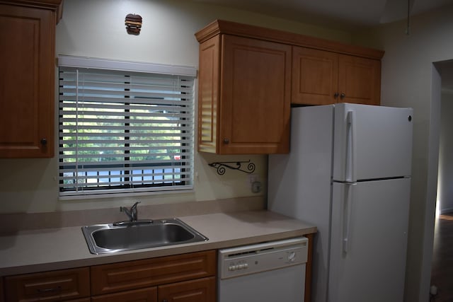 kitchen with fridge, white dishwasher, and sink