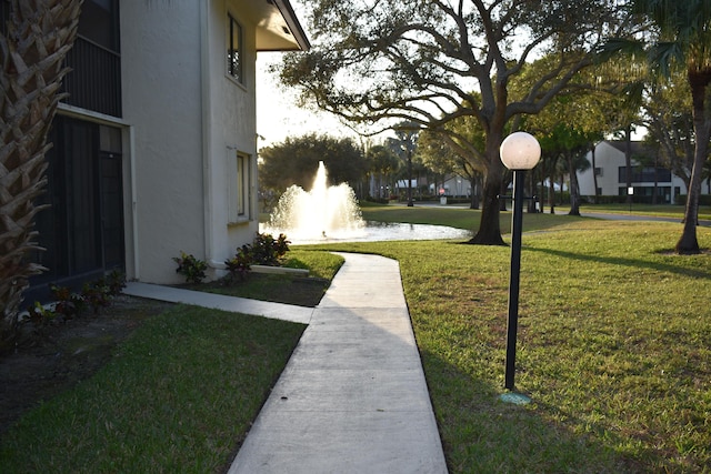 view of community with a water view and a lawn