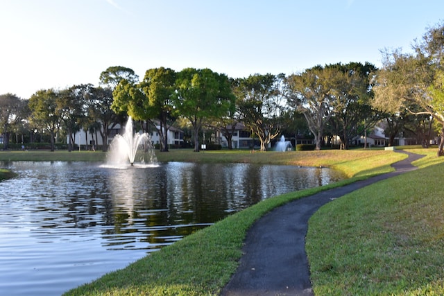 view of community featuring a water view and a lawn