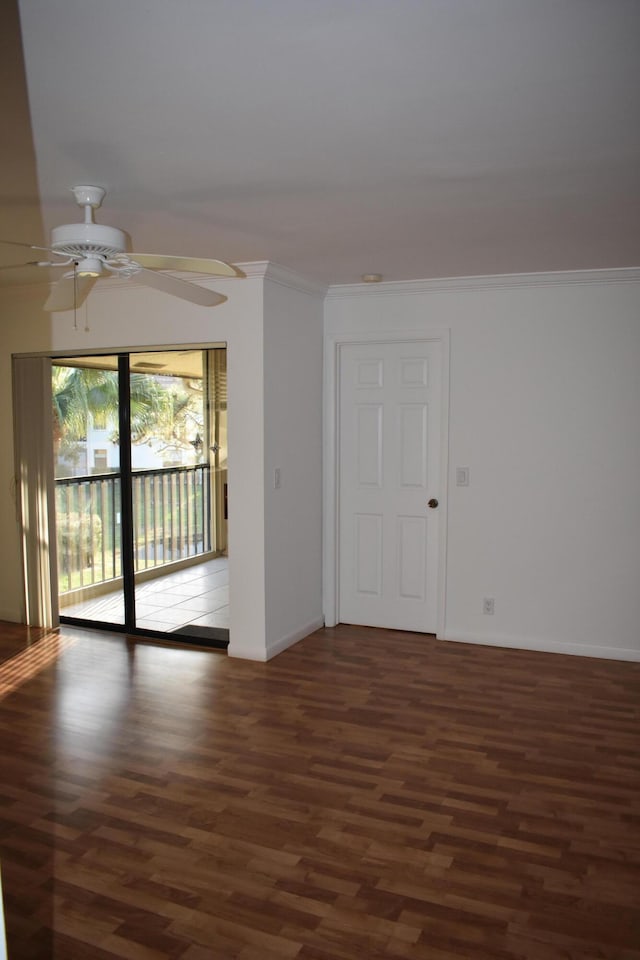 empty room featuring crown molding, dark wood-type flooring, and ceiling fan