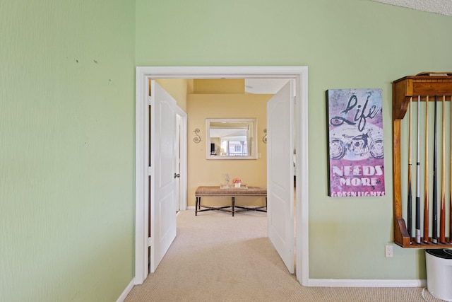 hall with light colored carpet