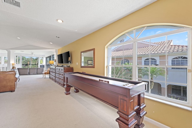 playroom featuring ceiling fan, lofted ceiling, carpet, and a textured ceiling