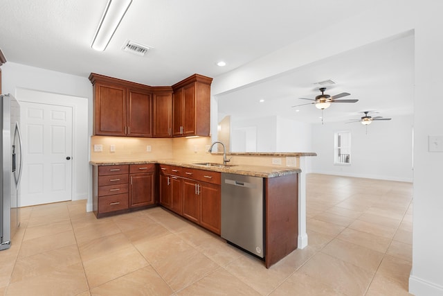 kitchen featuring sink, stainless steel appliances, tasteful backsplash, light stone countertops, and kitchen peninsula