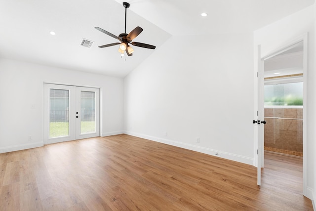 empty room with lofted ceiling, light hardwood / wood-style floors, and french doors