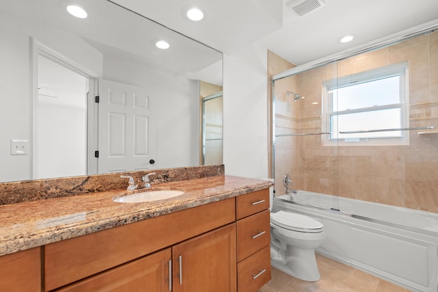 full bathroom featuring enclosed tub / shower combo, vanity, tile patterned floors, and toilet