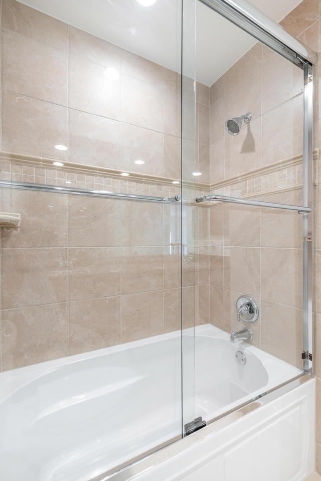 bathroom featuring combined bath / shower with glass door