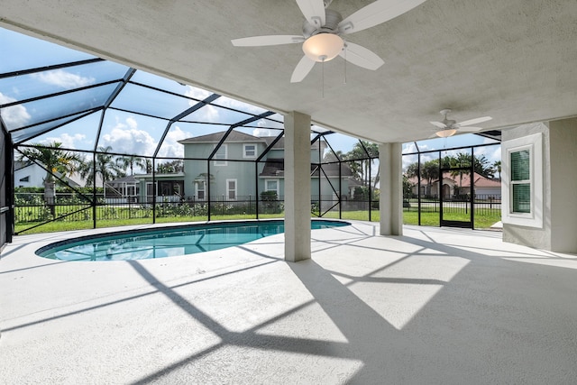 view of pool with ceiling fan, a yard, glass enclosure, and a patio area