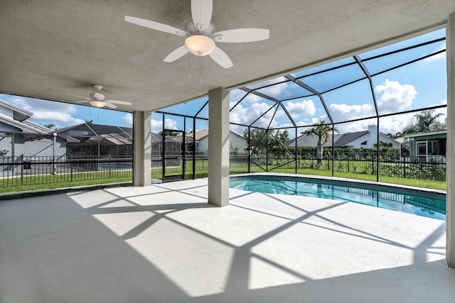 view of swimming pool featuring ceiling fan, a lanai, a patio area, and a lawn