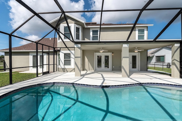 rear view of house featuring a patio, glass enclosure, ceiling fan, and french doors