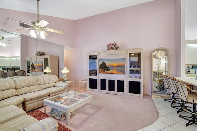 tiled living room with ceiling fan and high vaulted ceiling