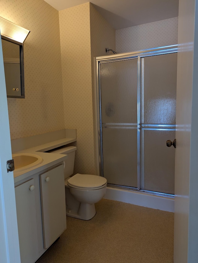 bathroom with an enclosed shower, vanity, and toilet