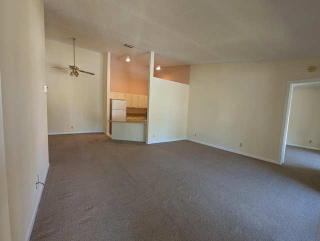 unfurnished living room featuring ceiling fan, vaulted ceiling, a textured ceiling, and carpet